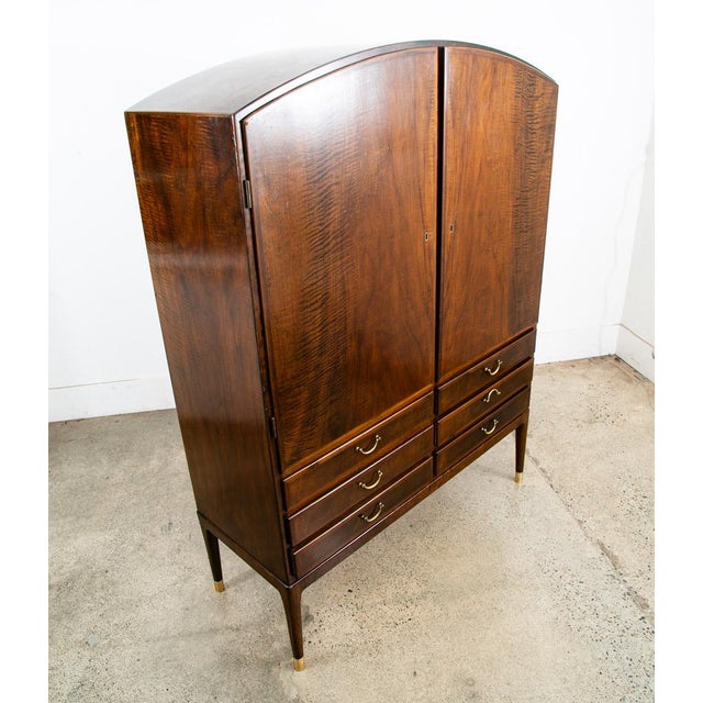 Unique and well crafted Danish modern sideboard. This arched walnut piece offers 2 sections, one storage are behind the...