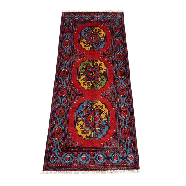 This tribal Oriental runner features three colorful Filpa, or elephant foot, medallions set along a vivid red field. Slate...