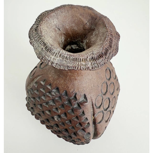 Signed 1976 Brutalist style stoneware vase with sections of circle and diamond patterns alternating down the side panels,...