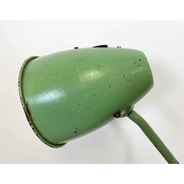 This green industrial style iron table lamp was made in former Czechoslovakia. It features an iron shade ,base and arm,...