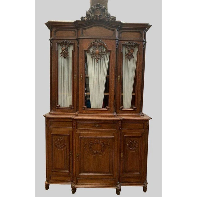 Liège sideboard in two sections Made of solid oak Upper section glazed on three sides Beautifully carved sideboard with...