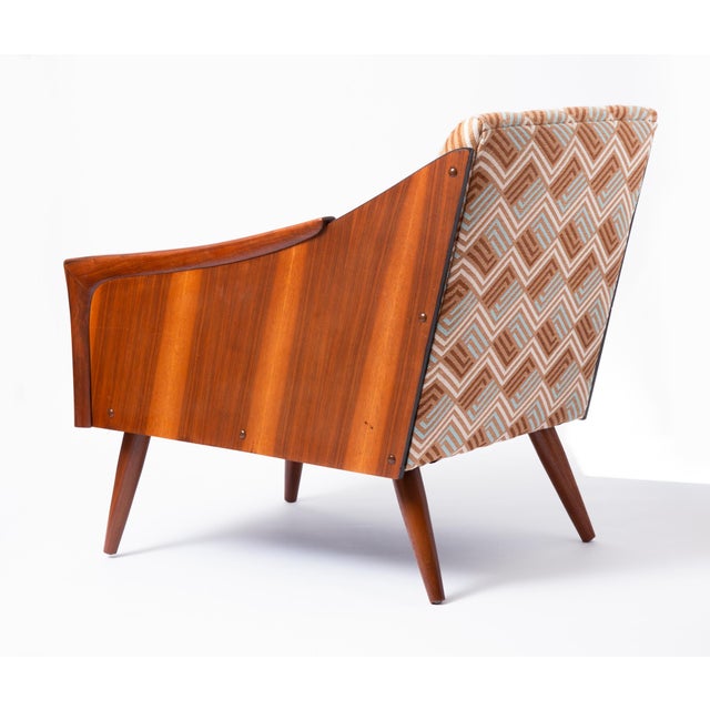 Unique Mid Century Lounge Chair with solid walnut arms and legs and walnut veneer sides. This chair is of unknown origin...