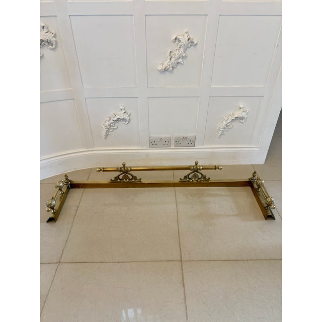 Antique Victorian brass fender crafted in solid brass and having a reeded and bobbin shaped design with scrolls, finials...