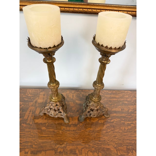 Add a dramatic touch of old-world elegance to your home with this beautiful matching pair of ornate vintage brass candle...