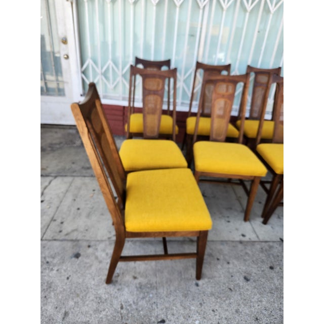 Vintage mid-century modern dining chairs with walnut-finished wood frames. This set of Eight features tall backs with...