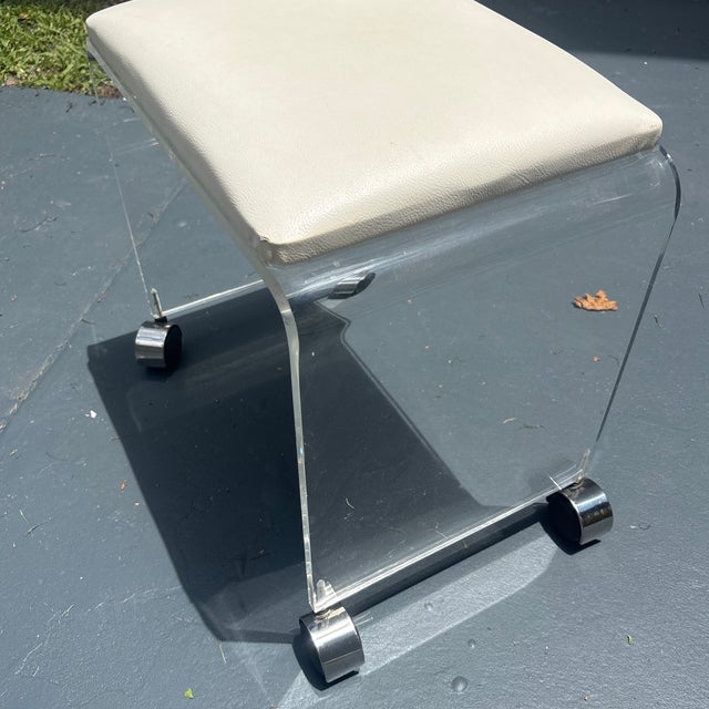 This elegant vanity stool is crafted from clear Lucite with a comfortable vinyl seat. Designed in a classic Mid-Century...