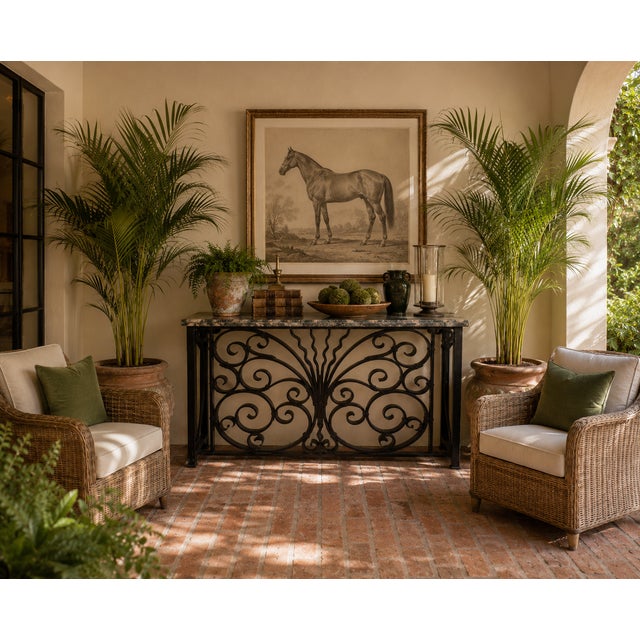 This striking vintage console table features an architectural wrought iron base adorned with intricate scrollwork and a...