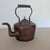 A handsome 19th-century English copper kettle with a beautifully aged surface, warm patina, arched handle, and elongated...