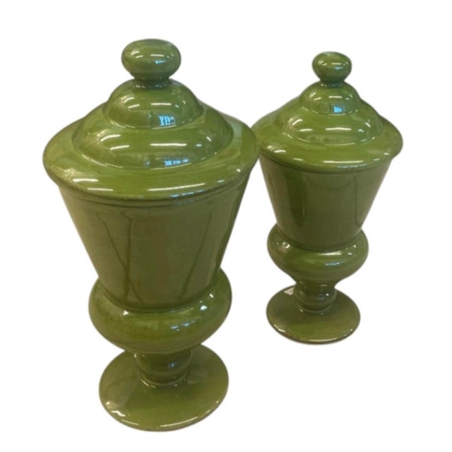 Elevate your home decor with this striking pair of vintage ceramic urns finished in a rich, glossy olive green glaze....