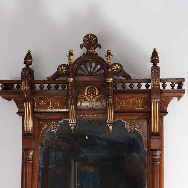 An exquisite Eastlake Aesthetic hall mirror, crafted from rich walnut and burl wood, dating to approximately 1870. This...