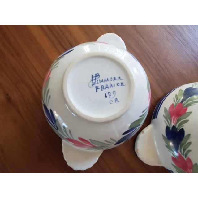 Stunning pair of antique HB Quimper handled bowls from Brittany, France. Both are worn, with a lovely rustic patina to the...