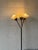 This striking floor lamp features a slender black metal stem and three adjustable gooseneck arms. The conical shades cast...
