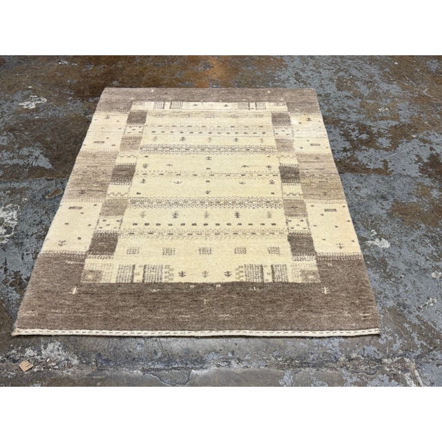 Design Plus Gallery presents a Kashkuli Gabbeh Wool Area Rug. Woven from 100% wool, this compact rug displays a...