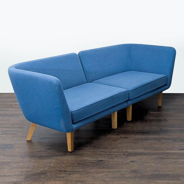 This Knoll sectional features a modern design with clean lines and a sturdy wooden base. The blue upholstery is both...