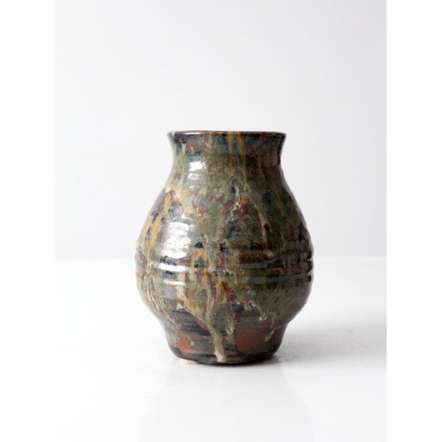 A vintage handmade studio pottery vase with a rounded baluster form and a richly variegated glaze in earthy tones of rust,...