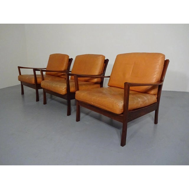 Danish rosewood armchair with loose leather cushions. Three armchairs available. All cushions have zippers and original...