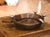 Sculptural and rustic, this decorative serving bowl by Jan Barboglio combines hand-carved wood with whimsical cast iron...