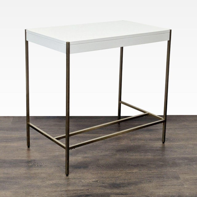 This West Elm desk features a sleek white tabletop and sturdy brass metal frame. Its compact size makes it perfect for...