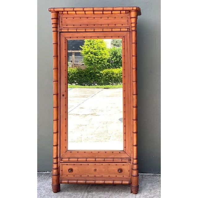 This remarkable late nineteenth-century armoire is expertly crafted from fine wood and mirrored glass, capturing the...