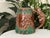 A mid century hand-painted ceramic art pottery mug crafted by Shafford. This highly detailed, dimensional piece features a...