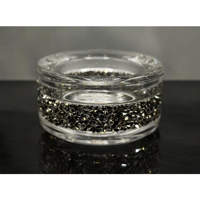 The black-transparent Swarovski candle holder is a refined design element, characterized by the mastery of the Crystal...