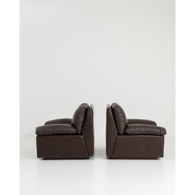 A stylish pair of Italian armchairs reflecting 1970s design sensibilities, combining comfort with sculptural form. The...