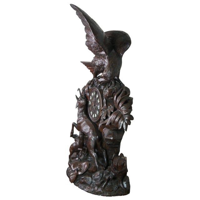 Monumental 19th century antique German Black Forest mantel clock featuring carved high relief details with a winged bald...