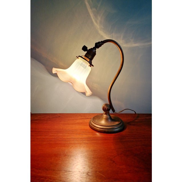 Art Nouveau desk lamp in bronze and opalescent glass with a glass shade, early 20th century. The lamp is articulated at...