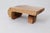 This unique low table or bench is carved from a single piece of wood, showcasing a monolithic form that feels grounded and...