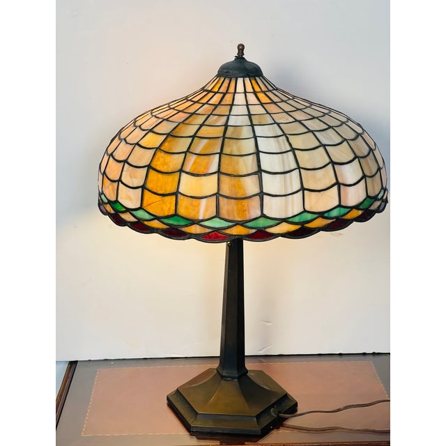 Elegant antique Tiffany Studios style table lamp. Bronze base for two bulbs, glass polychrome stained glass shade....