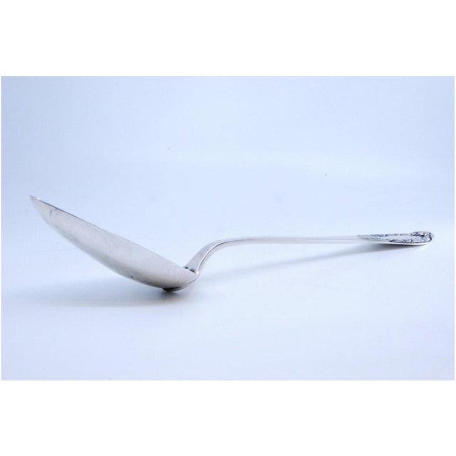 Silver Rice and Serving Spoon with Reliefs and Medallion Handle, in Very Good conditions. Designed 1890 to 1919 This piece...