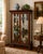 An elegant antique mahogany curio cabinet showcasing classic English-inspired craftsmanship with richly carved details and...