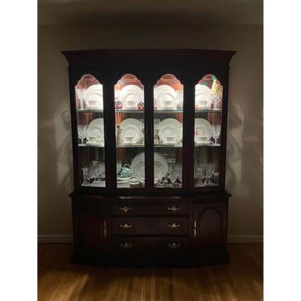 Elegant traditional china cabinet featuring a rich cherry-toned wood finish, beautiful crown molding, and classic...