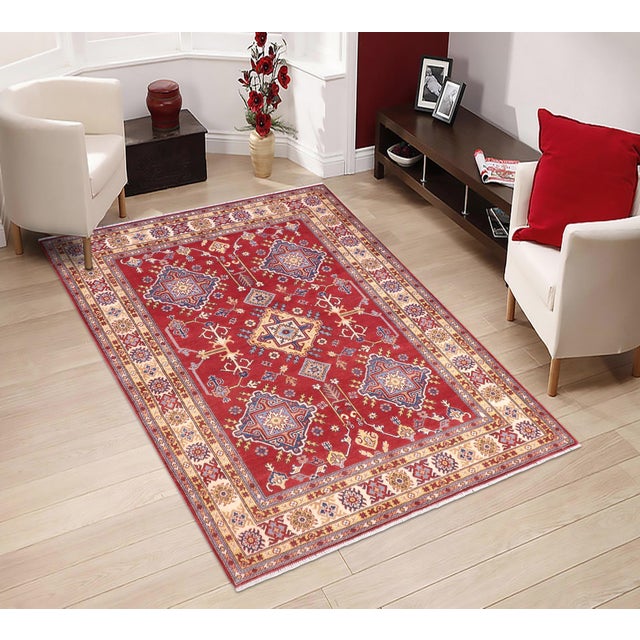 Enhance your home with this exquisite hand-knotted Kazak rug, crafted from fine hand-spun wool and dyed with all-natural...