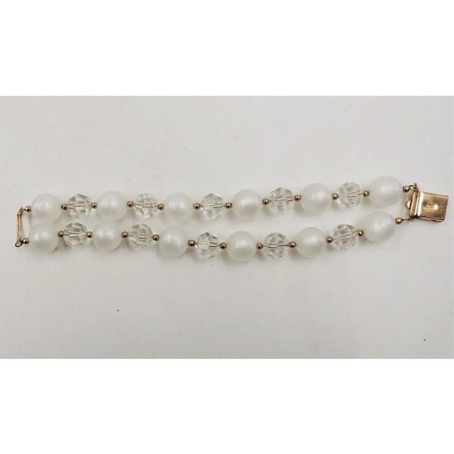 This is part of Chairish’s Costume Jewelry assortment. Early 1960s goldtone cut glass and white "moonglow" faux-moonstone...