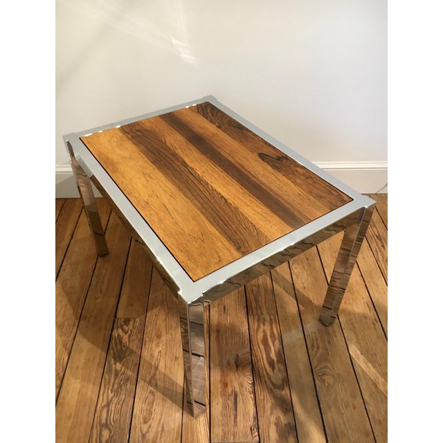 This 1970s Mid-Century Modern-style coffee table features a simple, but elegant chrome frame. The base is highlighted by a...