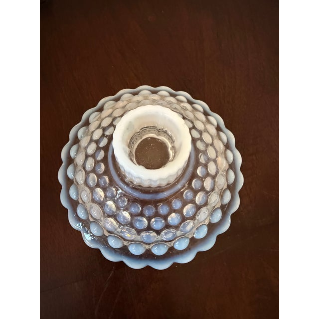 Delightful vintage pair styled after Fenton in luminous blue opalescent glass, including a hobnail candlestick and a...