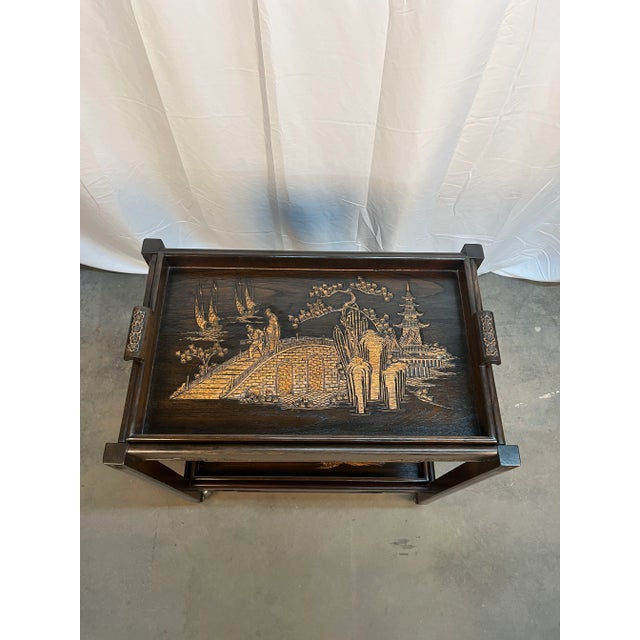 Beautiful and unusual wooden two-tiered Asian Butler’s Tray table. Trays feature two different hand carved images...