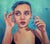 In One Ear, Out the Other by MJ Lindo | Oil on wood panel portrait of a young woman touching her face For Sale