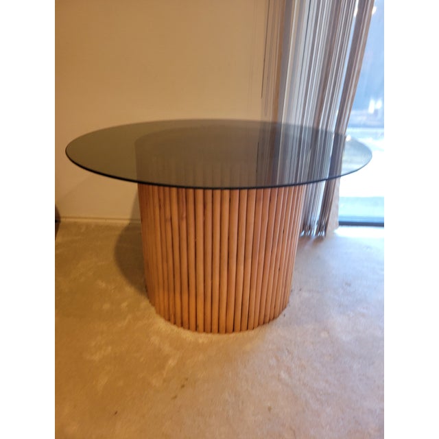 Vintage but modern round table featuring an expresso decorative glass top resting over a sculptural cylindrical slatted...