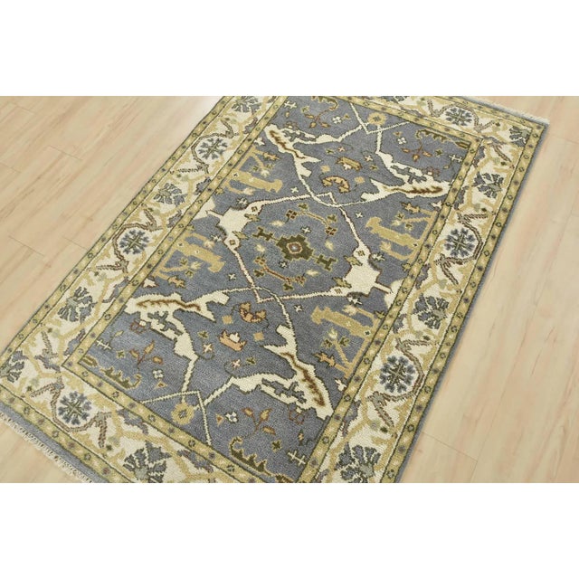 This traditional tribal Oushak rug is hand-knotted with an all-wool pile on a cotton foundation. This rug is new and in...