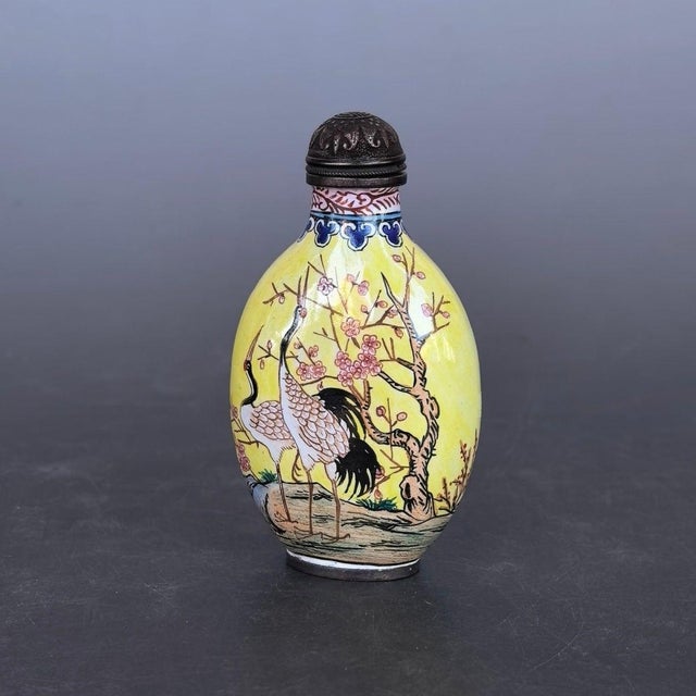 This is a charming vintage Chinese snuff bottle, crafted from a copper body with hand-painted enamel decoration. The...