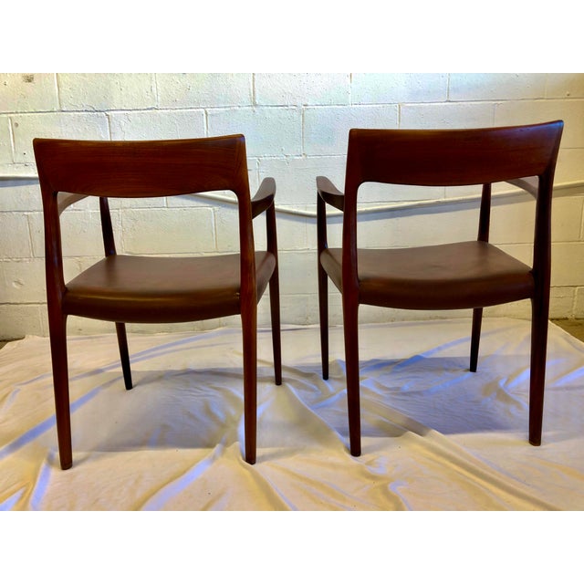 A pair of rosewood armchairs with original brown leather seats. There isn’t a tag, but with proper research they are Model...