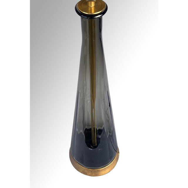 the tall and striking ribbed art glass lamp of conical form in luminous smoked glass all resting on a brass base; Empoli...