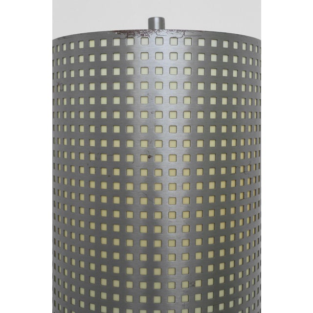 Rare sleek minimalist floor lamp by George Kovacs, featuring a perforated cylindrical metal shade on a slim stem and round...