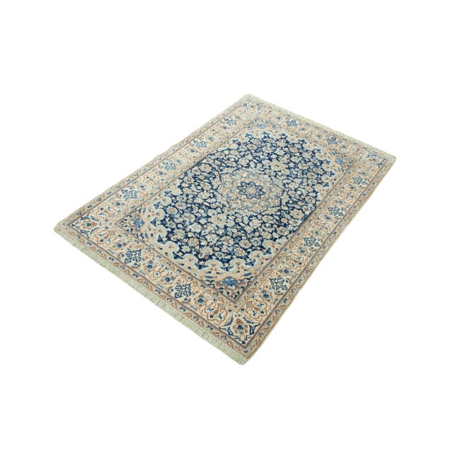 This elegant Nain 9La oriental rug impresses with its detailed floral pattern in sophisticated shades of dark blue, beige,...