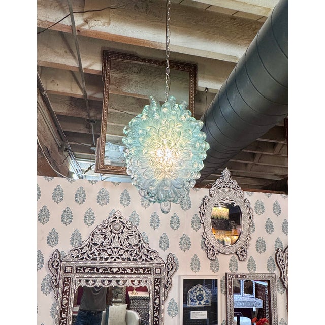 An outstanding clear and transparent pendant crafted from recycled hand-blown glass. This striking sculptural light...