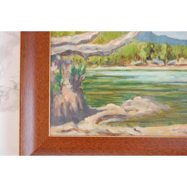 Vintage Oil on Canvas Lakeside Landscape, Signed This serene landscape painting features a calm waterfront. Mountains in...