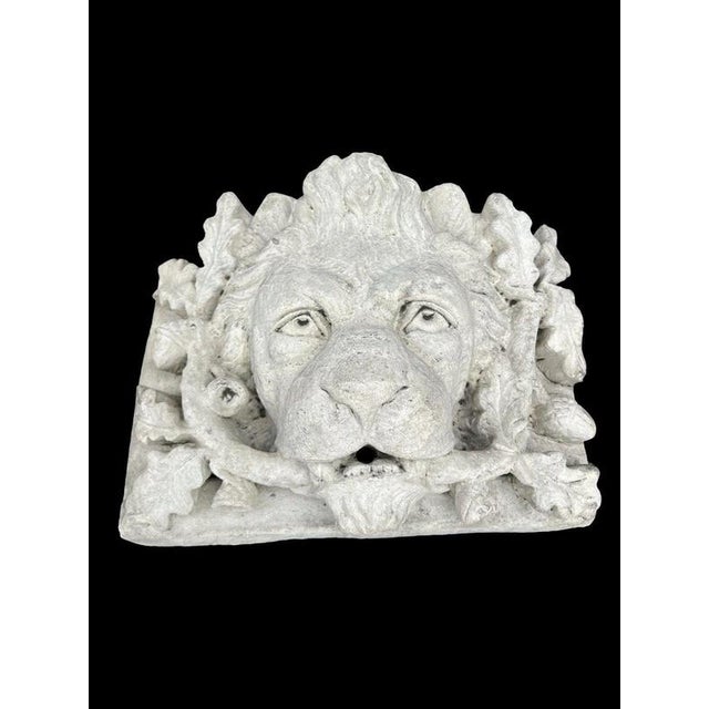 A substantial architectural lion head wall plaque or fountain mask, richly modelled with the lion’s face emerging from an...