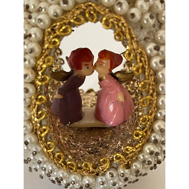 Vintage Christmas Ornament made in a shape of beaded open face agh with pair of miniature angels kissing. Unique...